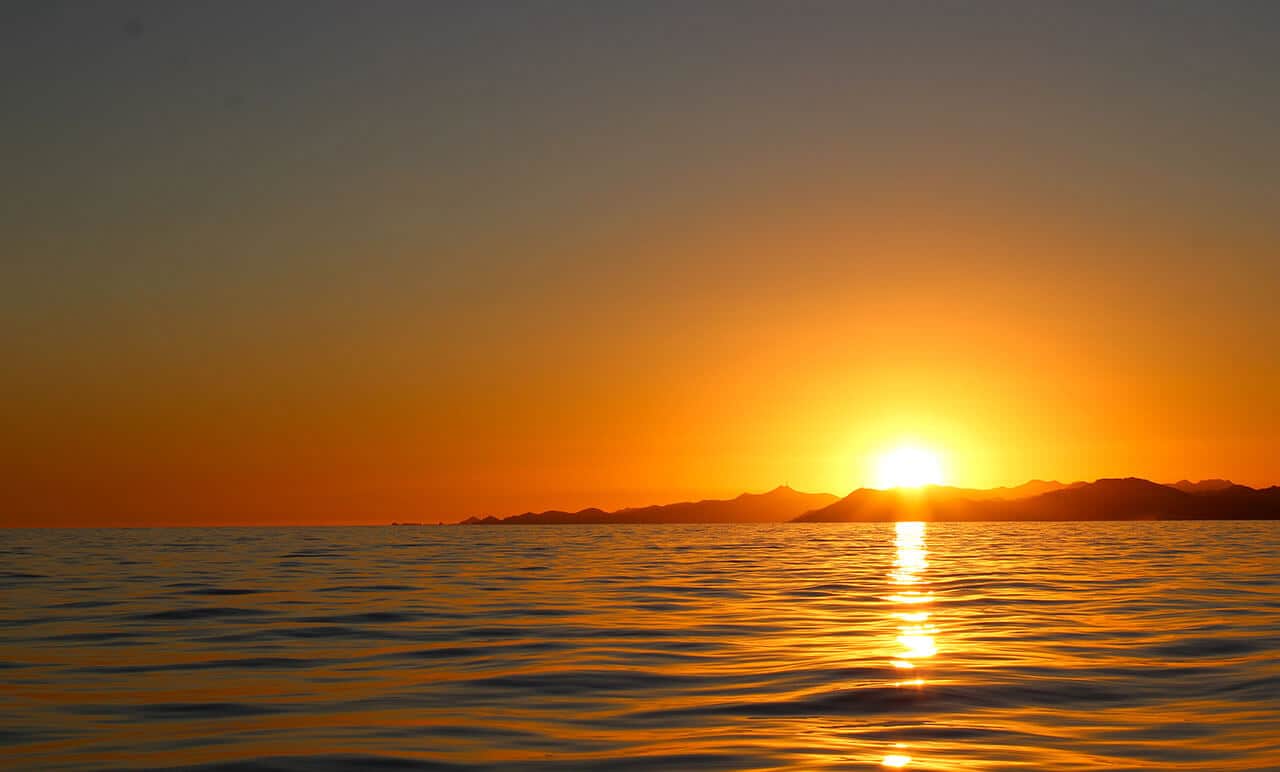 Sun setting over the ocean with glowing color band at Costa Azul