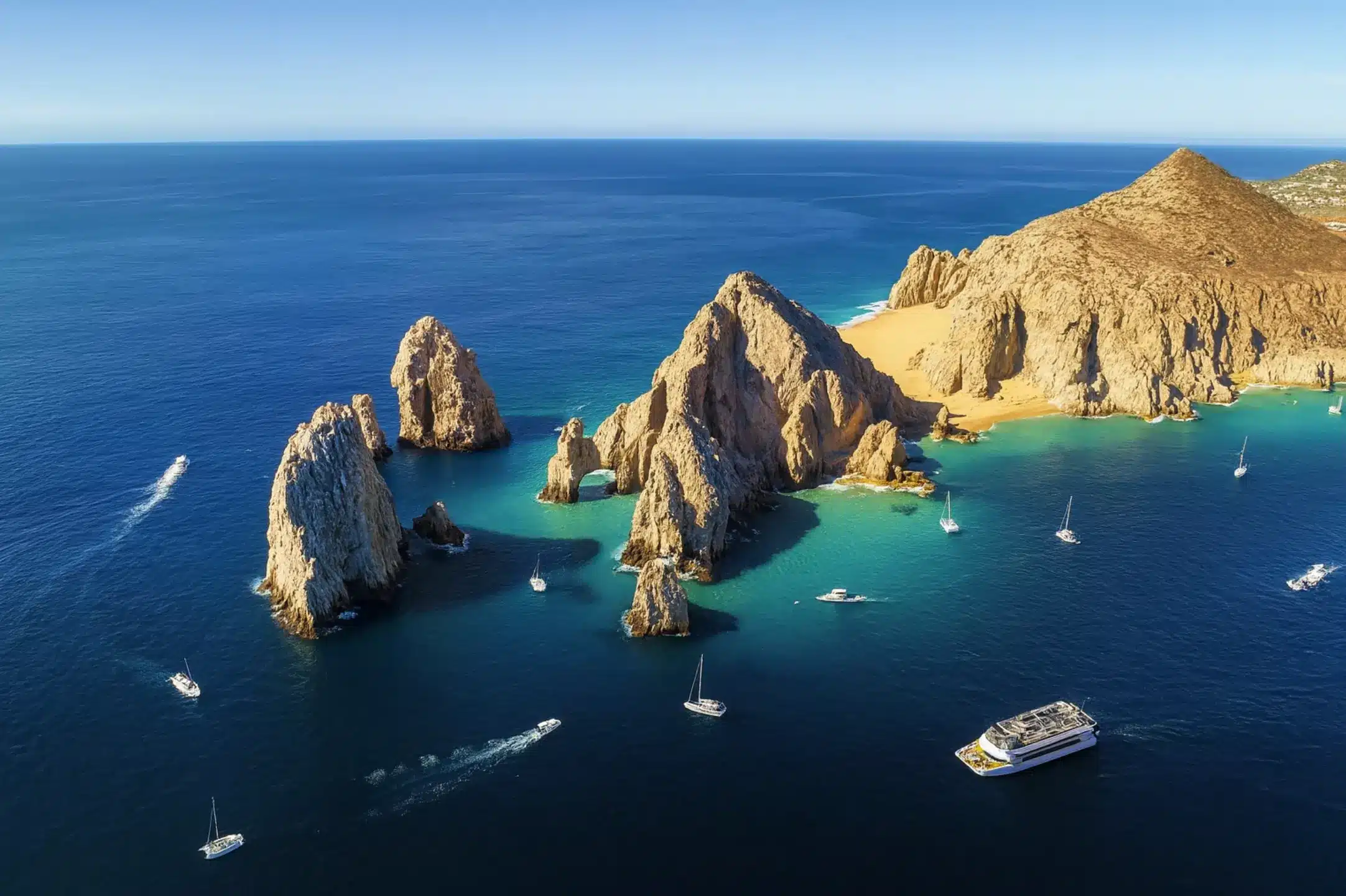 Aerial perspective of Cabo San Lucas with the Arch and boats at sunset