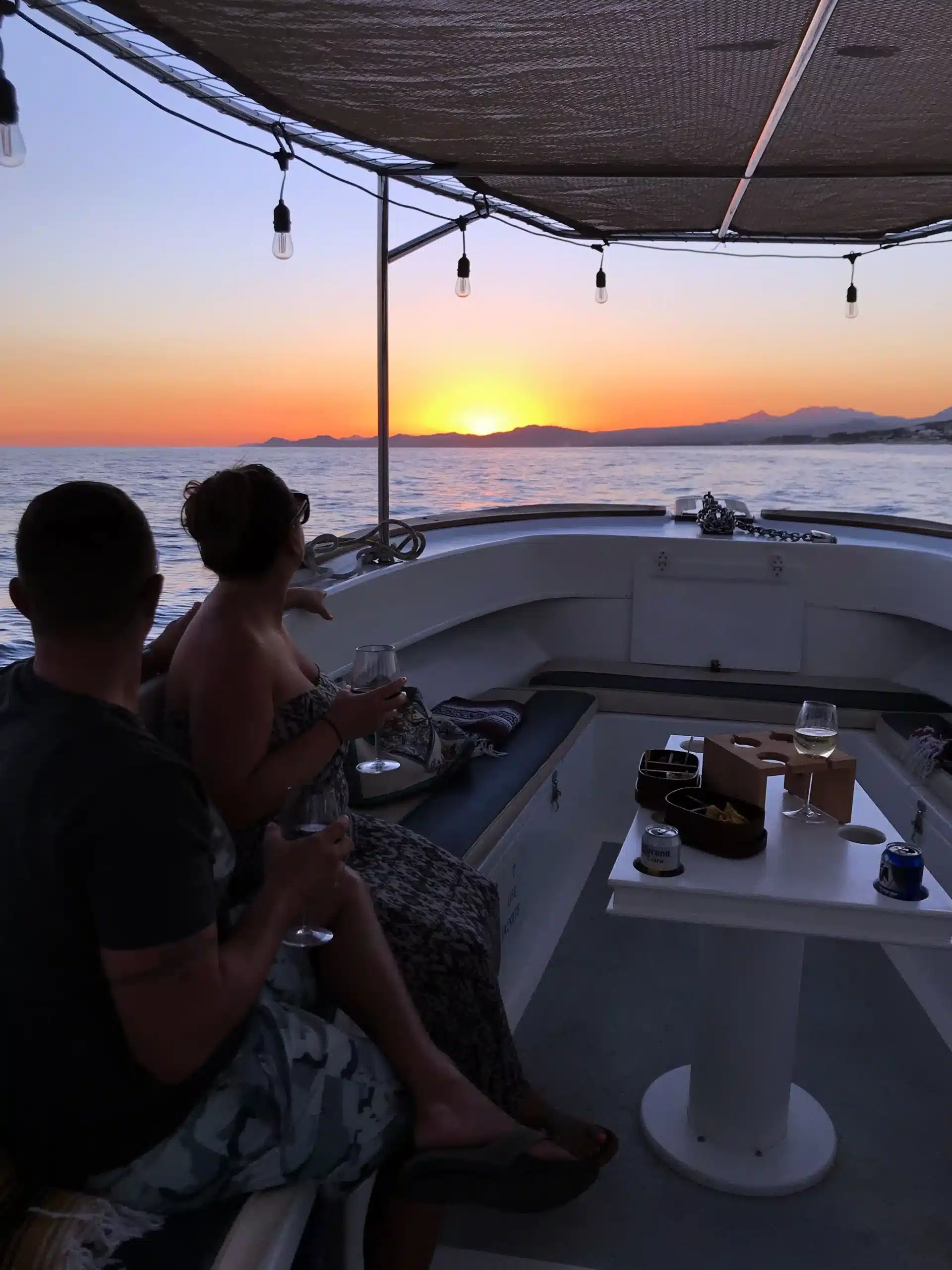 Couple enjoys boat at sunset with vivid skies – Best Sunset Photography in San José del Cabo – Top Spots