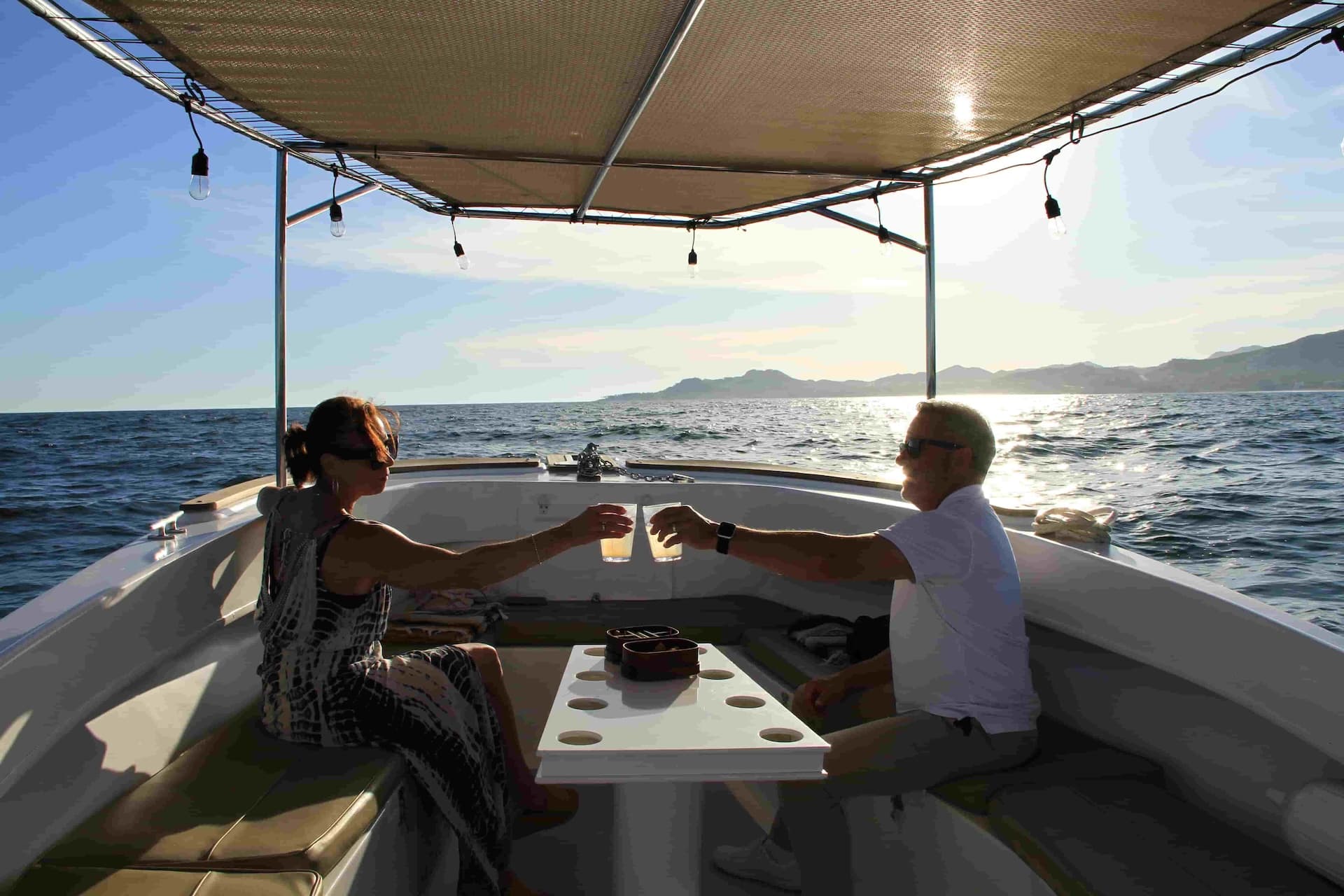 Couple enjoying drinks aboard a Salty Cabo sunset cruise on the Sea of Cortez in San José del Cabo.